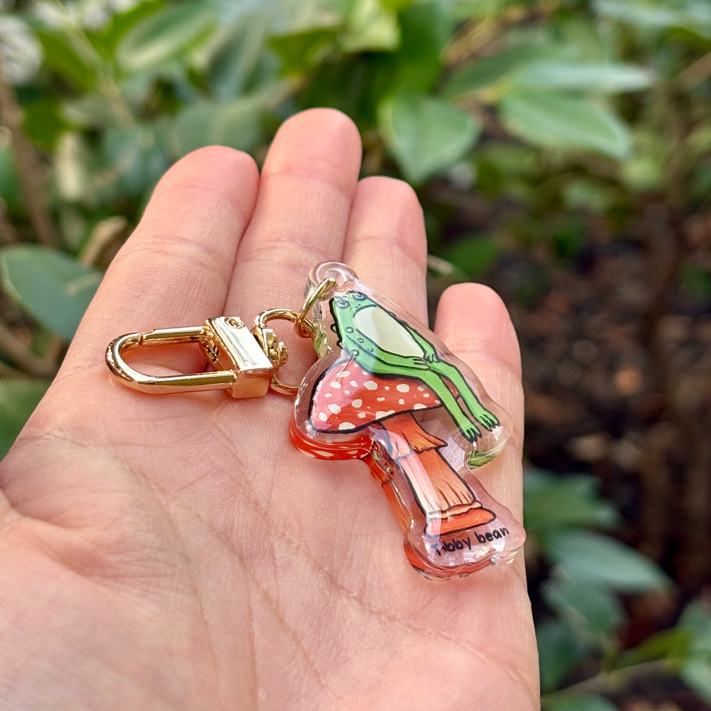 Acrylic sitting toad on mushroom keychain