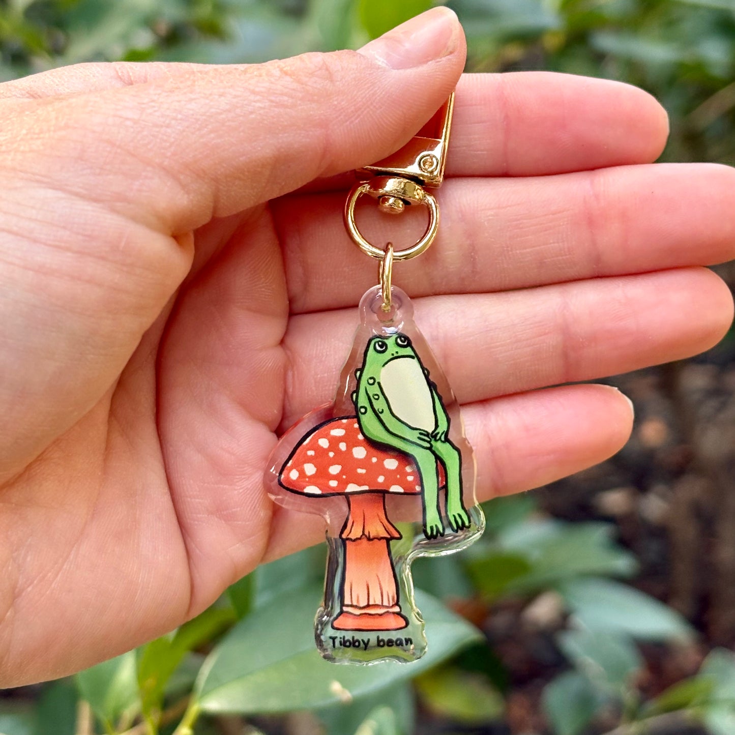 Acrylic sitting toad on mushroom keychain