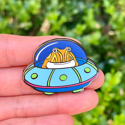 Tibby the frog in a UFO enamel pin