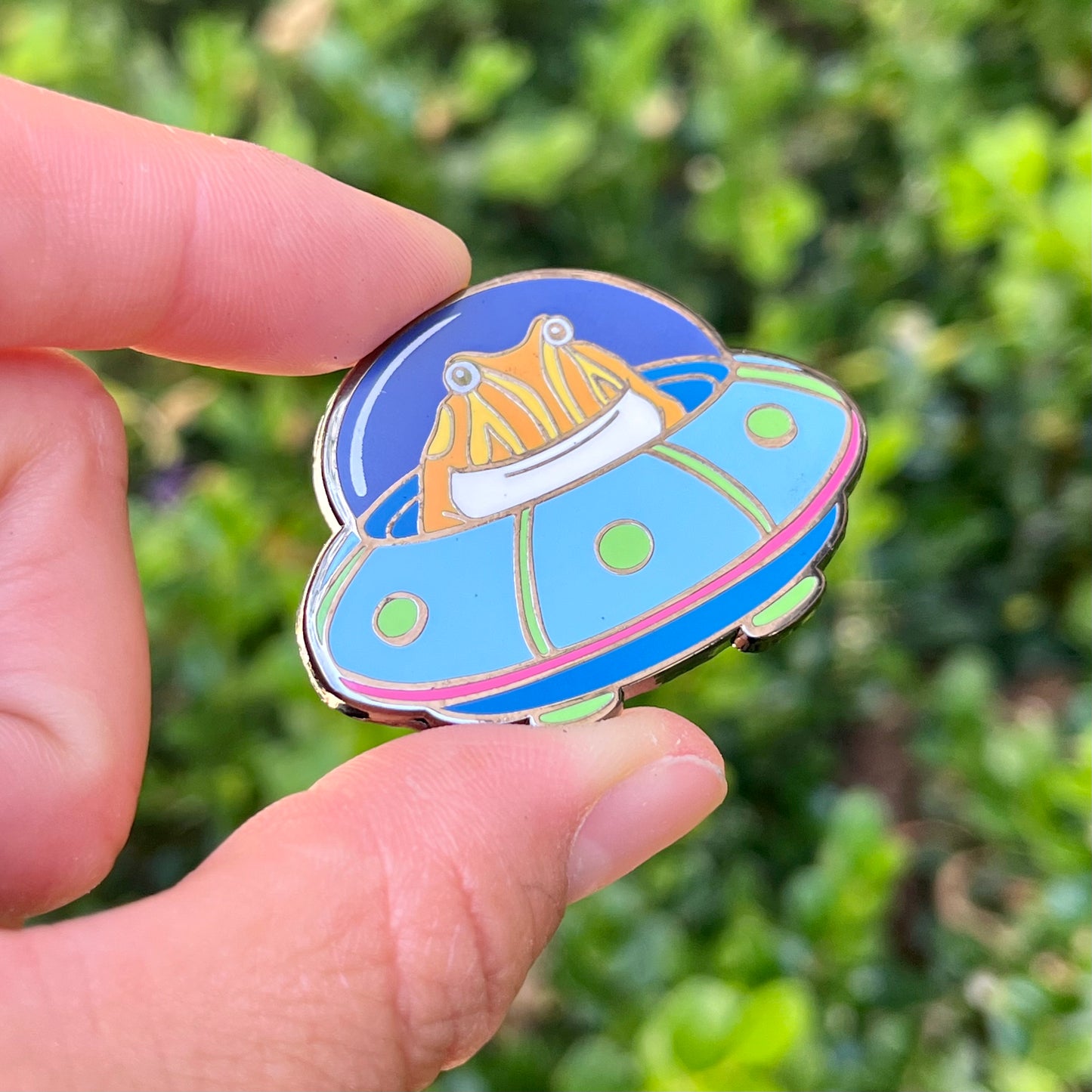 Tibby the frog in a UFO enamel pin